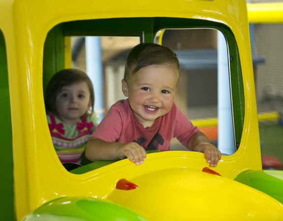 Two toddlers smiling and playing inside a colorful playground structure, Allstars Indoor Playland Edmonton